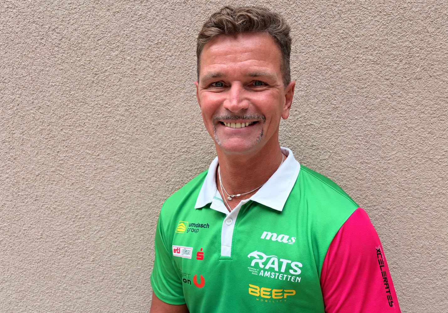 Lächelnder Mann im grünen Team-Polo